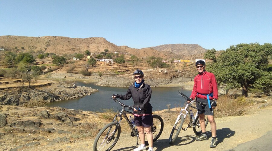Cyclist riding through picturesque village in Rajasthan, India.