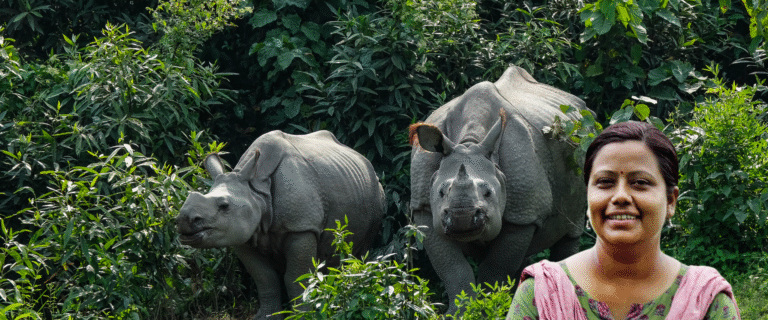Dr. Sonali Ghosh standing near a one-horned rhinoceros at Kaziranga National Park, Assam, India